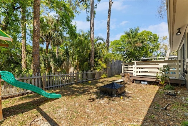 view of yard featuring a wooden deck, fence private yard, and an outdoor fire pit