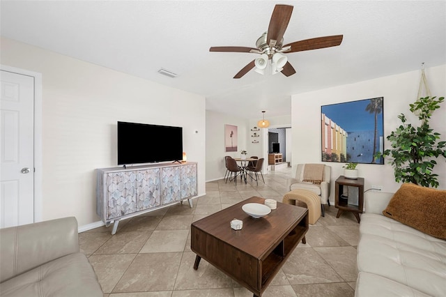 living room with light tile patterned flooring, visible vents, and ceiling fan