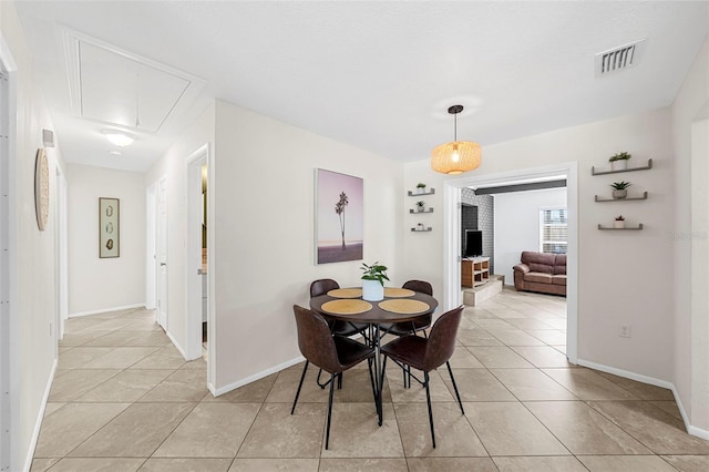 dining area featuring light tile patterned floors, visible vents, baseboards, and attic access