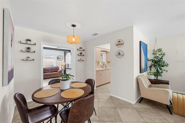 dining space featuring light tile patterned flooring, visible vents, and baseboards