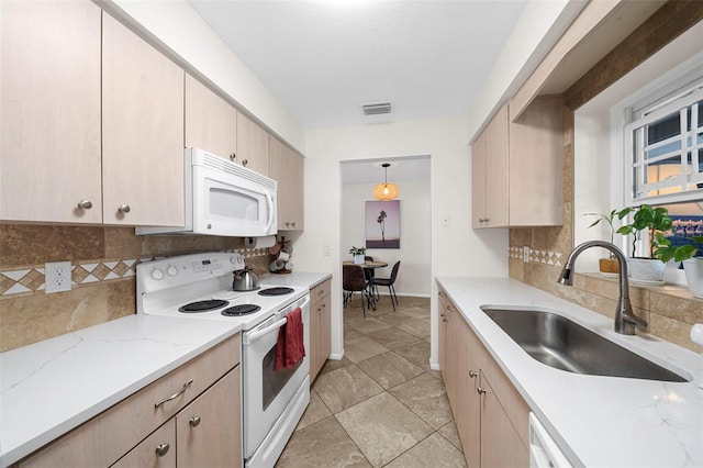 kitchen featuring white appliances, light brown cabinets, visible vents, a sink, and backsplash