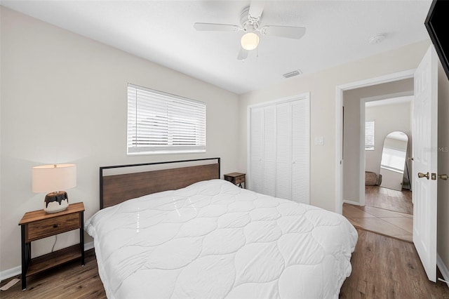 bedroom featuring visible vents, multiple windows, and wood finished floors