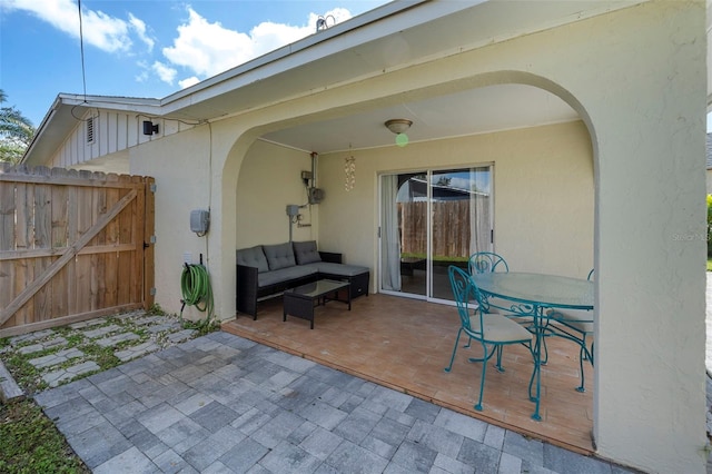 view of patio featuring outdoor dining space, an outdoor hangout area, and fence