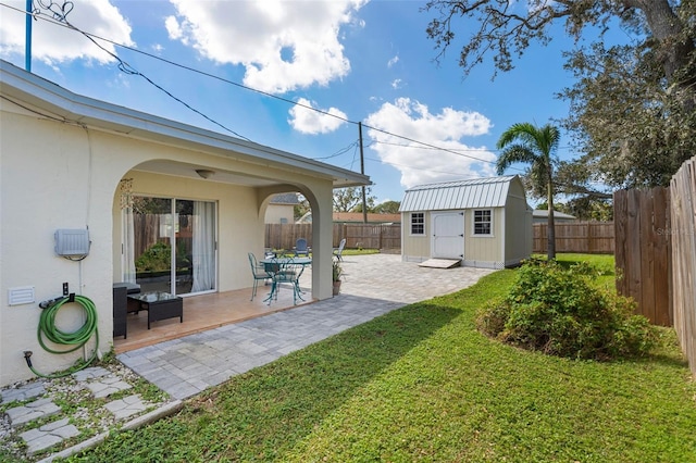 view of yard with an outbuilding, a fenced backyard, a shed, and a patio