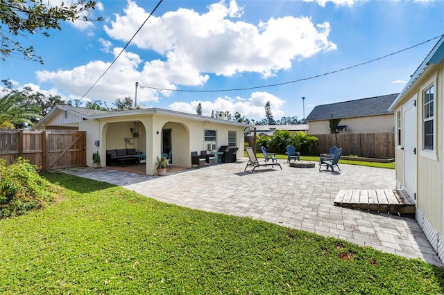 rear view of property with a yard, a patio, and fence