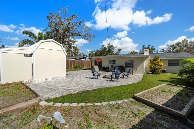 back of house featuring fence, a shed, a lawn, a garden, and a patio area