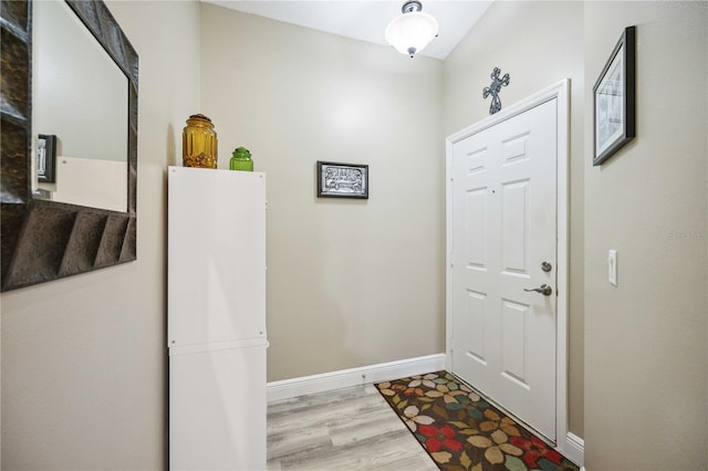 doorway with baseboards and wood finished floors