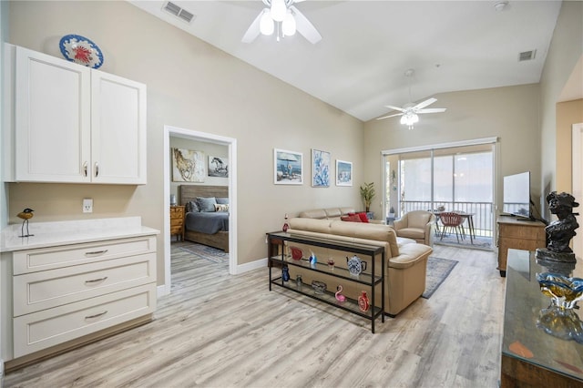 living area featuring visible vents, ceiling fan, and vaulted ceiling