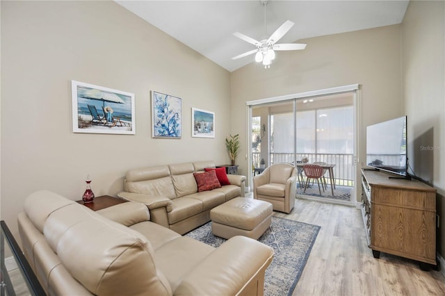 living area featuring vaulted ceiling, light wood finished floors, and ceiling fan