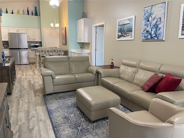 living area with a high ceiling and light wood-style flooring