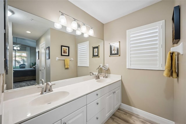 ensuite bathroom with a sink, baseboards, double vanity, and ensuite bathroom