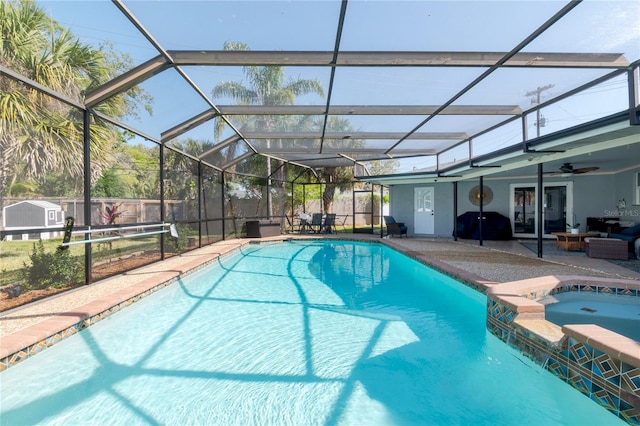 view of pool featuring glass enclosure, a pool with connected hot tub, and a patio area