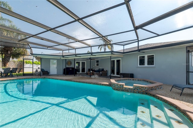 view of swimming pool featuring glass enclosure, a pool with connected hot tub, ceiling fan, french doors, and a patio area