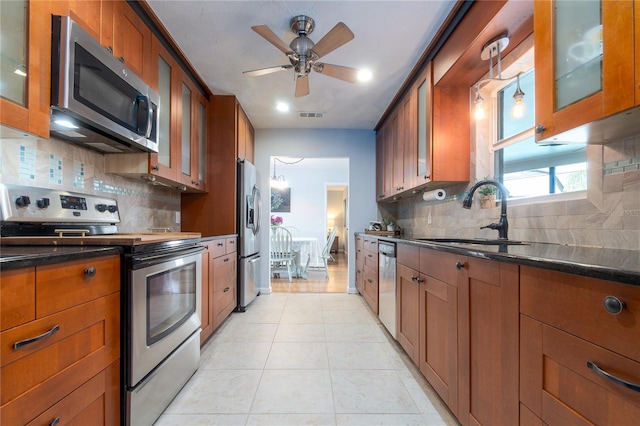 kitchen featuring a sink, brown cabinetry, visible vents, and stainless steel appliances