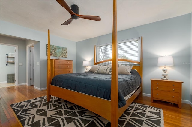 bedroom with baseboards, wood-type flooring, and a ceiling fan