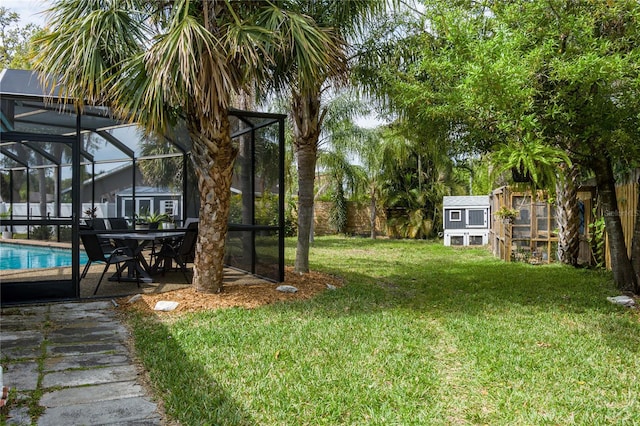 view of yard with a lanai, a patio area, an outdoor pool, and an outdoor structure