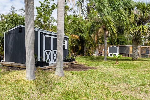 view of yard with an outbuilding, a shed, and fence