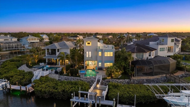 aerial view at dusk with a residential view and a water view