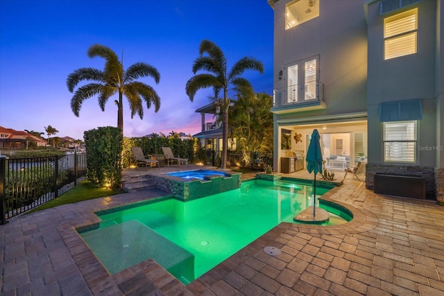 view of swimming pool with a patio area, a pool with connected hot tub, and a fenced backyard