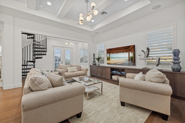 living area with visible vents, stairs, recessed lighting, an inviting chandelier, and wood finished floors