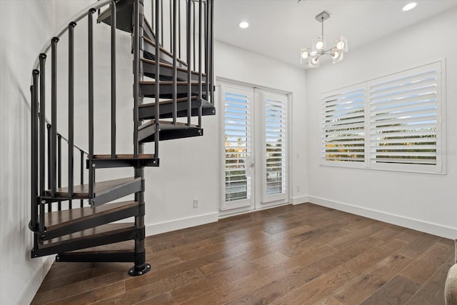 staircase featuring baseboards, a healthy amount of sunlight, and wood finished floors