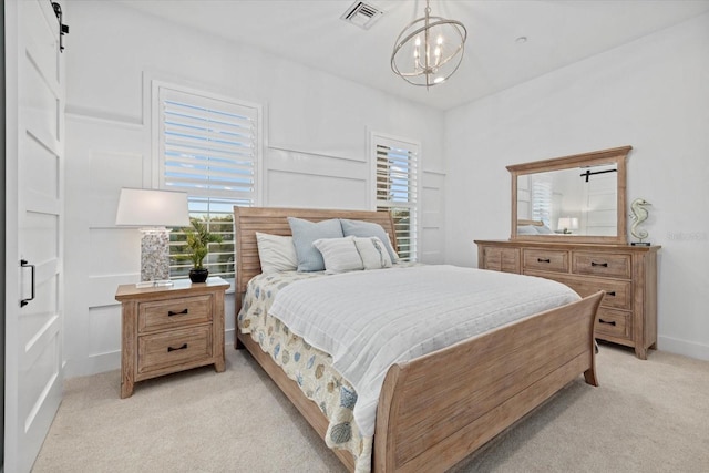 bedroom featuring light carpet, visible vents, multiple windows, and a barn door