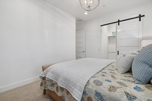 bedroom featuring a notable chandelier, baseboards, a barn door, and carpet floors