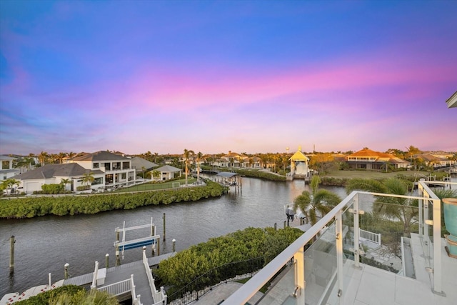 property view of water with a residential view, boat lift, and a dock