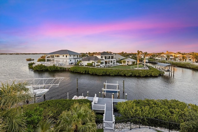 dock area featuring a water view, a residential view, and boat lift