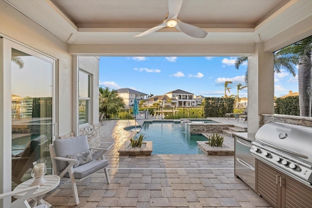 view of swimming pool with exterior kitchen, a pool with connected hot tub, ceiling fan, a patio area, and a grill