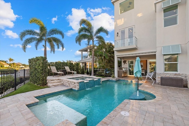 view of swimming pool with a patio area, fence, and a pool with connected hot tub