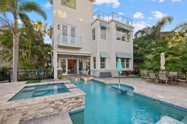 back of property with a patio, a balcony, fence, and stucco siding