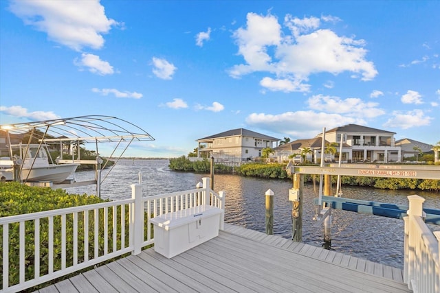 dock area with a water view, a residential view, and boat lift