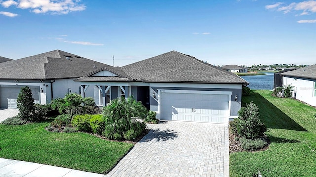 ranch-style house featuring a garage, decorative driveway, a front lawn, and a shingled roof