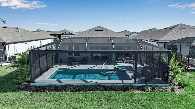 back of house with glass enclosure, a patio, cooling unit, a pool with connected hot tub, and a lawn