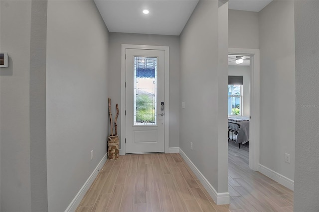 doorway to outside featuring a wealth of natural light, baseboards, and light wood finished floors