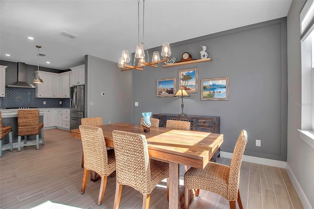 dining space with baseboards, visible vents, wood tiled floor, recessed lighting, and a chandelier