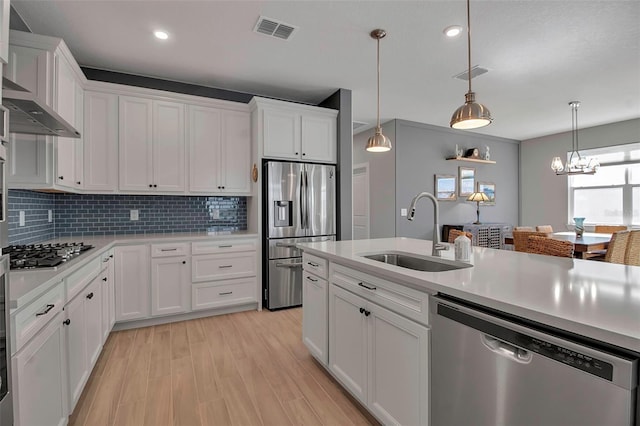 kitchen featuring visible vents, a sink, stainless steel appliances, light countertops, and white cabinets