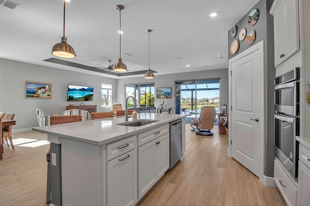 kitchen featuring visible vents, light countertops, appliances with stainless steel finishes, light wood-style floors, and a sink