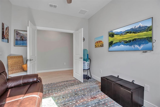 sitting room with visible vents, baseboards, and wood finished floors