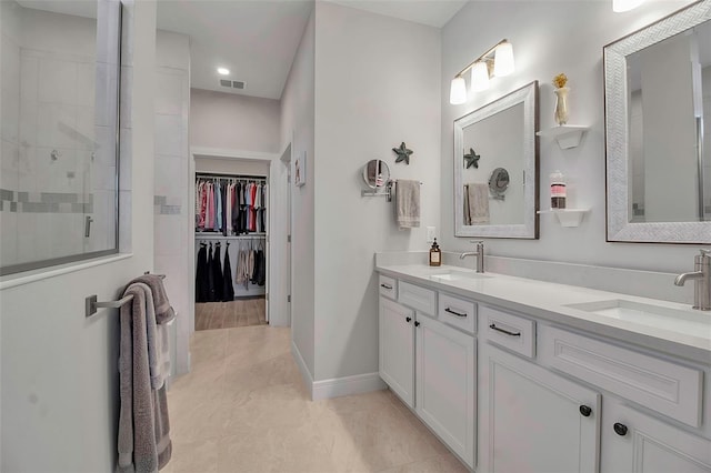 full bathroom featuring a sink, visible vents, double vanity, and a tile shower