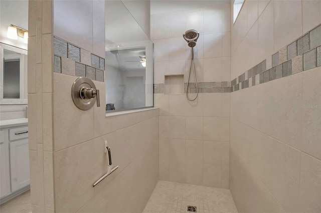 full bathroom featuring ceiling fan, vanity, and a tile shower