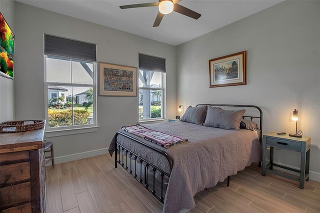 bedroom with baseboards, ceiling fan, and wood tiled floor