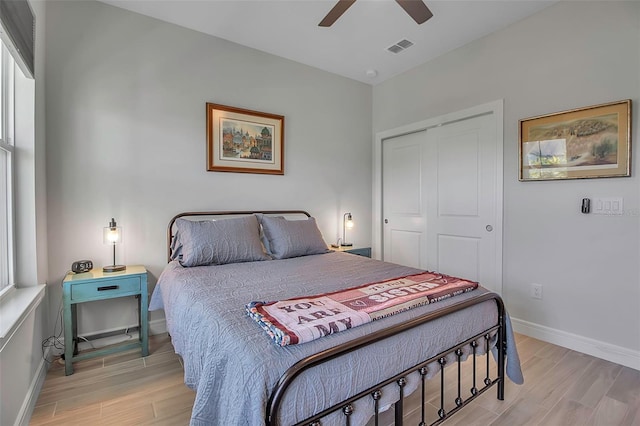 bedroom featuring visible vents, baseboards, light wood-style floors, and a closet