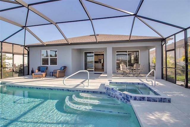 view of pool featuring glass enclosure, a patio area, and a pool with connected hot tub