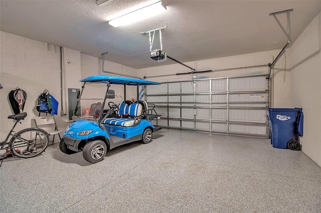 garage featuring concrete block wall and a garage door opener