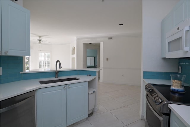 kitchen featuring a sink, stainless steel appliances, decorative backsplash, and light countertops