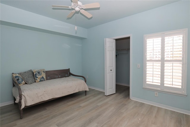 bedroom with wood finished floors, baseboards, a closet, and ceiling fan