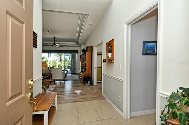 hallway with light tile patterned floors, baseboards, and visible vents