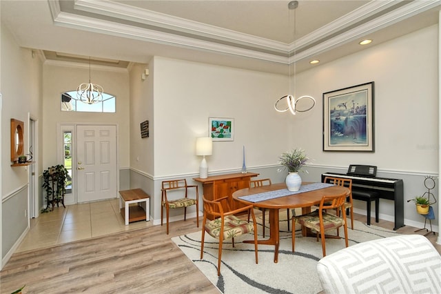 dining space with crown molding, a notable chandelier, baseboards, and light wood finished floors